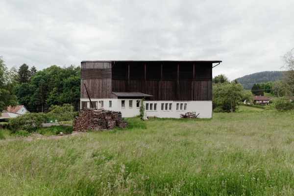 Bauernhof-Stall in gruener Landschaft