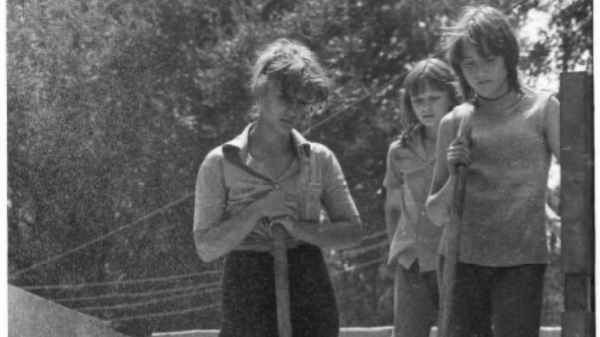 ©Franki Raffles, Women standing on sand with tools, Soviet Union, 1989 Frau steht auf Sand mit
                                          Schaufel , Soviet Union, 1989