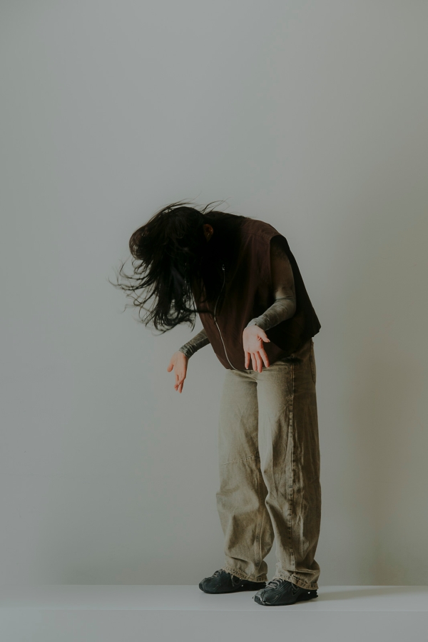 Eine
                                          Person mit gesenktem Kopf und offenen, nach vorne zeigenden Handflächen