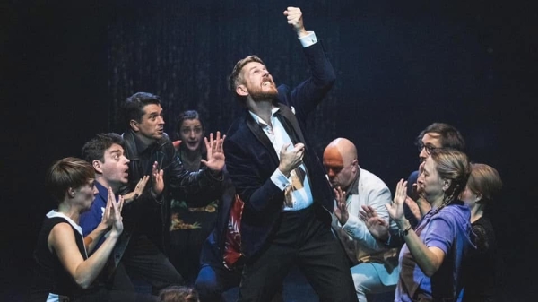 ©Tamás Künsztler Performer Jim Libby auf einer Bühne mit anderen Schauspielern