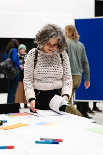 A woman is flipping through a publication at a Workshop
