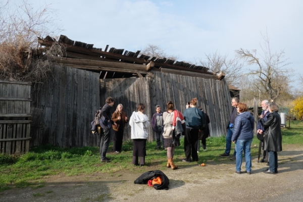 Eine Gruppe steht vor einer Holzhütte.