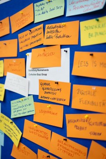 Colorful Post-its are pinned to a blue bulletin board